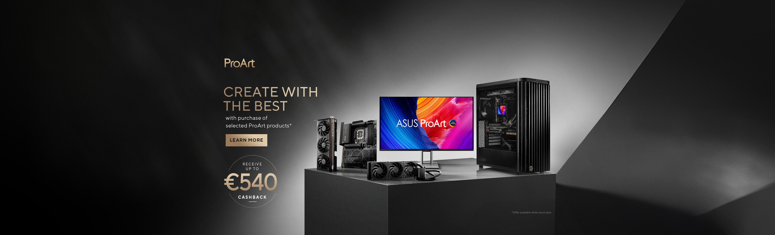 The image shows a promotion for ASUS ProArt products. On a black table are various hardware components: a monitor with ASUS ProArt written on the screen, a computer case with internal lights, and some components such as a graphics card and motherboard. On the left, there are promotional texts about possibly receiving cash-back of up to 540 euros with the purchase of selected ProArt products. The background has a gradient from black to gray.