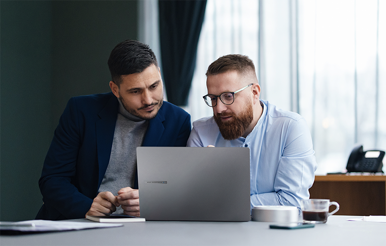 In a small business office, employees are working or discussing with each other.