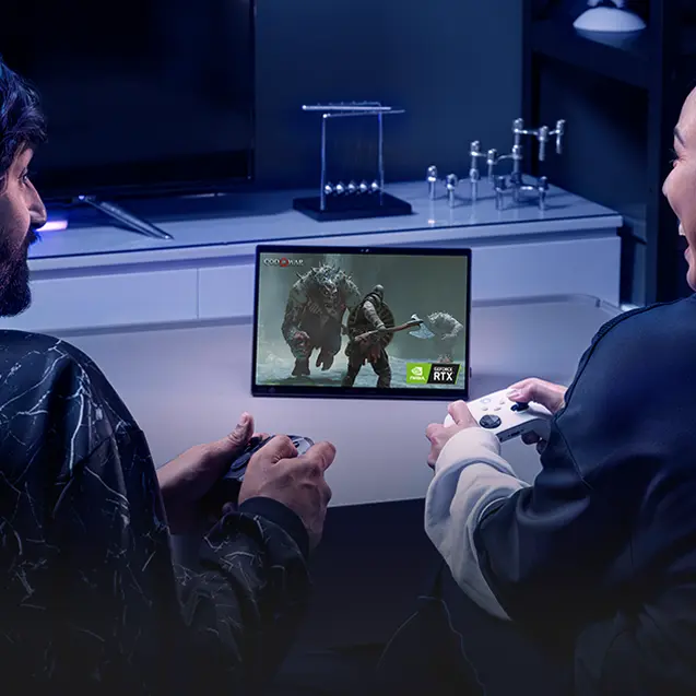 Two people sitting on a couch, enjoying the Portal RTX game with controllers and the Flow Z13.